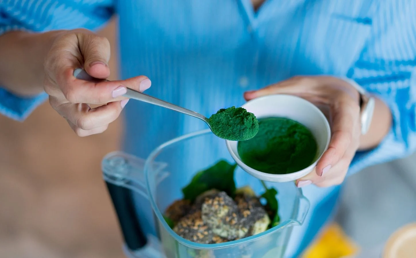 Fresh spirulina powder in a wooden spoon